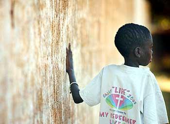 家に帰る道。ラエマさんは壁にもたれ、ゆっくり、ゆっくりと歩いた＝ザンビア・ルサカで６月１６日、梅村直承写す