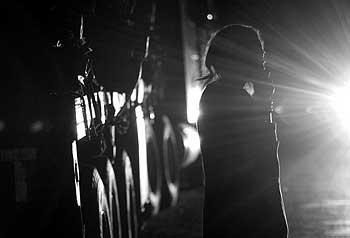列をなすトラックの前に立つ女性。その姿がヘッドライトに照らされた＝ザンビア・チルンドで、梅村直承写す